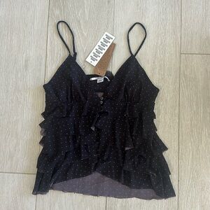 This is an urban outfitters size small black tank with light pink polkadots